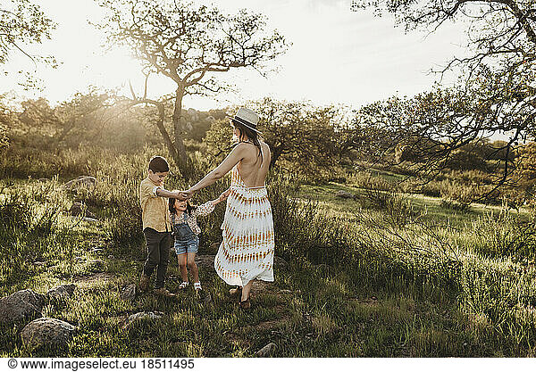 Beautiful mother and young children playing in sunny field