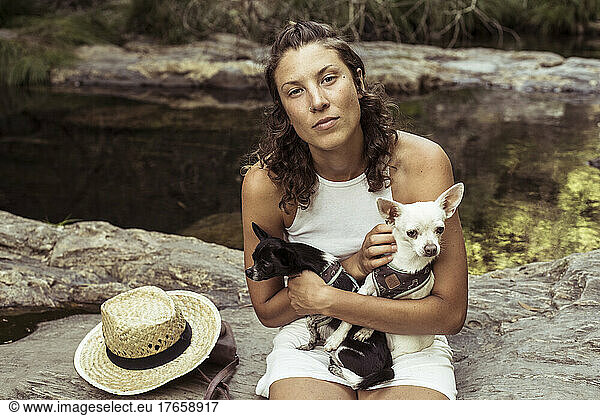 Beautiful person with small dogs looks calmly into camera