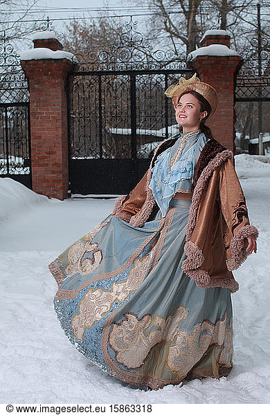 Beautiful Russian woman in a blue vintage dress. Russian village. Winter.