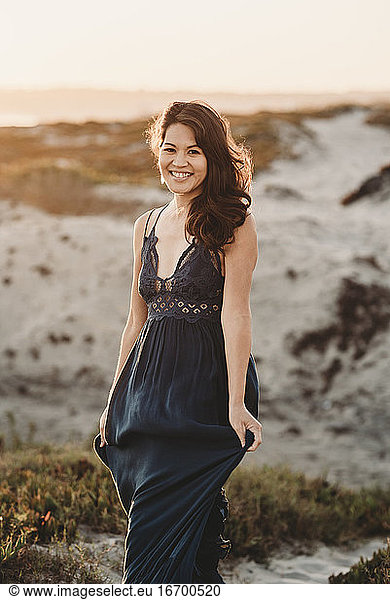 Beautiful smiling mid-40's woman in lacy dress on a sand dune