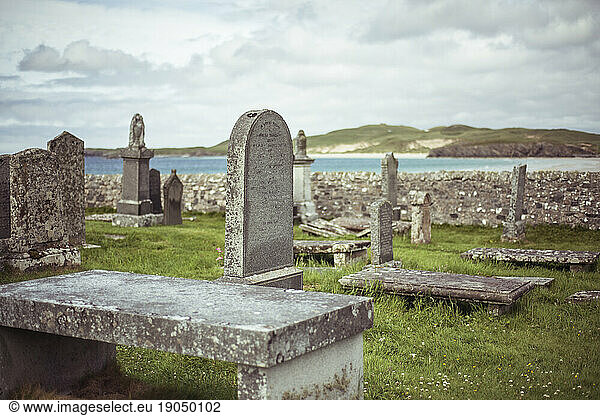 Beautiful stone headstones in graveyard by the ocean