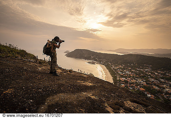 Beautiful sunset view to adventure photographer on hill top