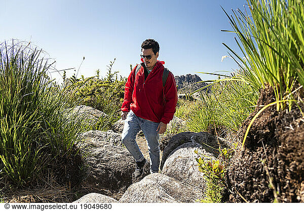 Beautiful view to man hiking on rocky mountains and altitude fields