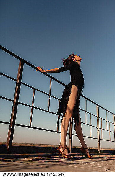 Beautiful woman feeling free latina dancing against the sunset sky