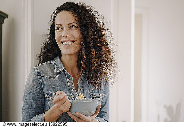 Beautiful woman having healthy breakfast eating granola