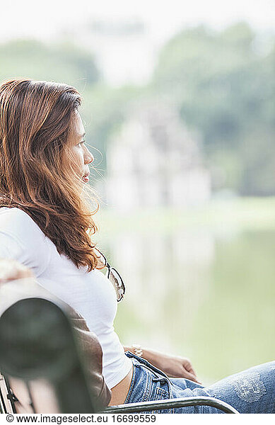beautiful woman relaxing at Hoan Kiem lake in Hanoi / Vietnam