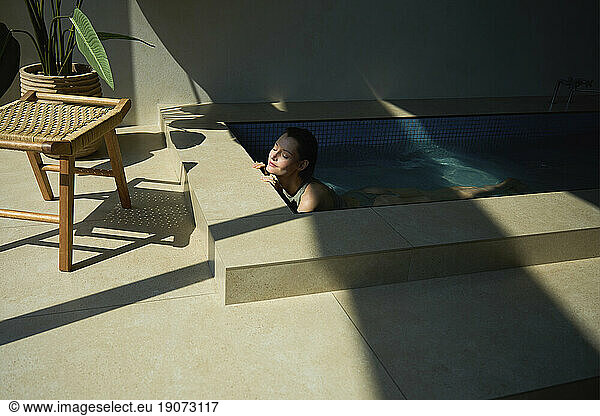 Beautiful woman relaxing in hot tub at spa