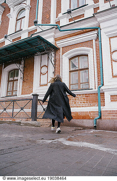 beautiful woman walks on the street in fashionable clothes