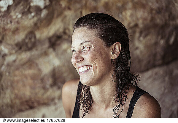 Beautiful woman with wet hair laughs at beach in Portugal