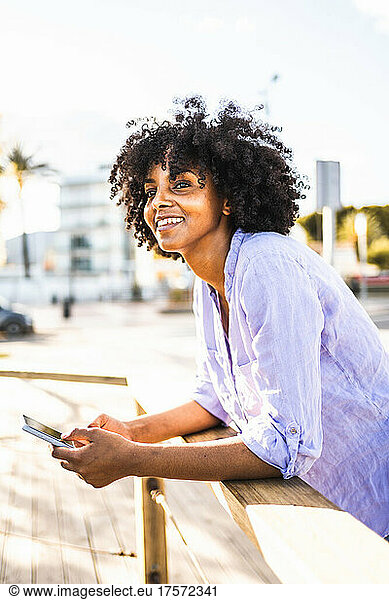 Beautiful young black woman happy while using her smartphone