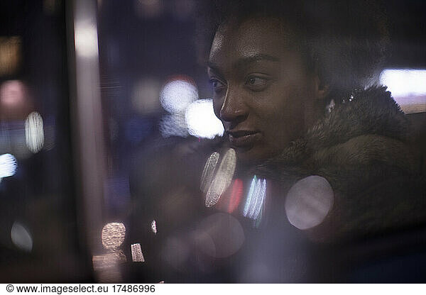 Beautiful young woman in car window at night