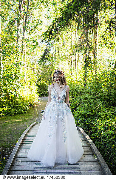 Beautiful young woman in white dress standing in nature.
