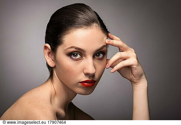 Beauty fashion girl. Portrait of beautiful young woman with fresh clean skin on grey background