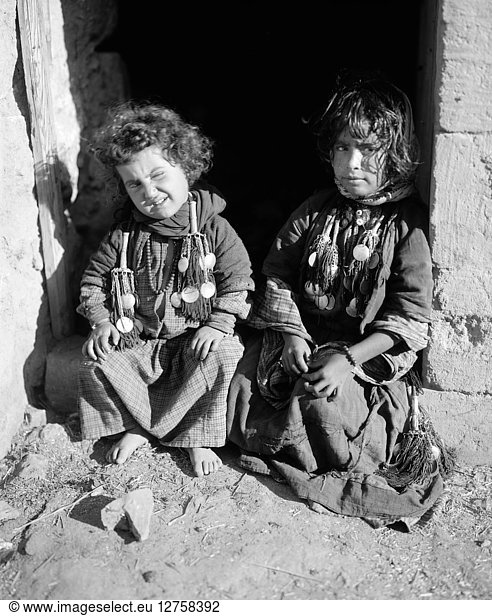 BEDOUIN CHILDREN. Two Bedouin children seated in a doorway in the Middle East. Photograph  early 20th century.