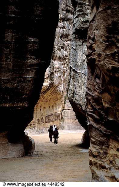 Bedouins walking inside the Siq  narrow gorge that leads to the Khasneh (´Treasury´). Petra. Jordan