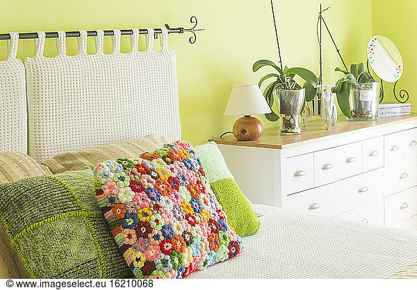 Bedroom bed with colorful floral cushion