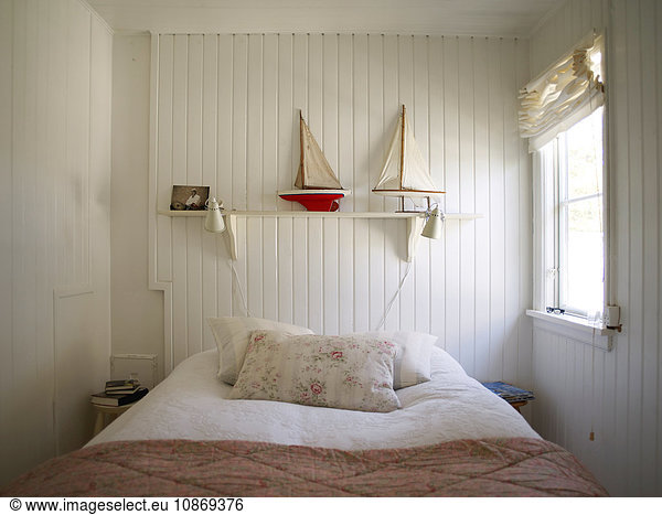 Bedroom with white wood panelling and bed