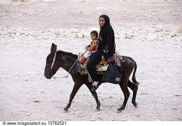 Beduinenfrau und Kind auf einem Esel in Petra