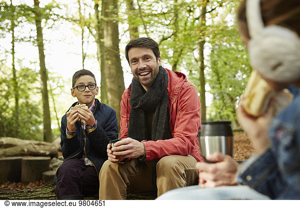 Beech woods in Autumn. Three people  a father and two children having a picnic.
