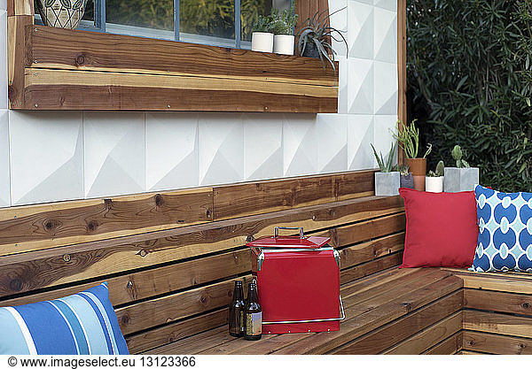 Beer bottles and cooler on wooden bench in backyard