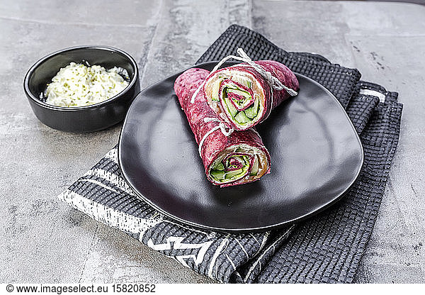 Beetroot wraps filled with ham  cheese  corn  iceberg lettuce  cucumbers and cream cheese