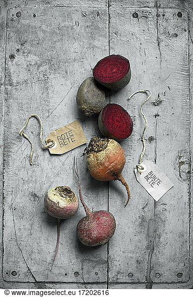 Beets and labels lying on gray wooden surface