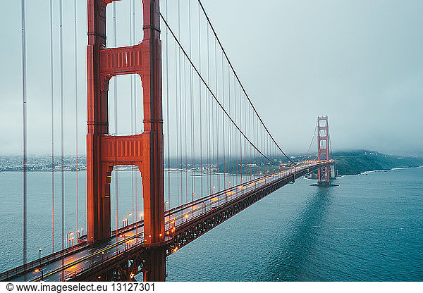 Beleuchtete Golden Gate Bridge gegen bewölkten Himmel