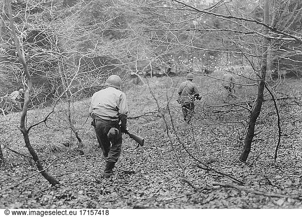 BELGIEN In der Nähe von Eupen -- 18. Dezember 1944 -- Eine Patrouille der US-Armee  Kompanie F  3d Bataillon  18. Infanterieregiment  1. Infanteriedivision  sucht in den Wäldern zwischen Eupen und Butgenbach  Belgien  nach deutschen Fallschirmspringern  die während eines großen deutschen Gegenangriffs  der später als Ardennenoffensive bekannt wurde  in diesem Gebiet abgeworfen wurden -- Bild von Runyan / Lightroom Photos / US Army *Bestmögliche Qualität. Nicht auf Staub oder Kratzer retuschiert.