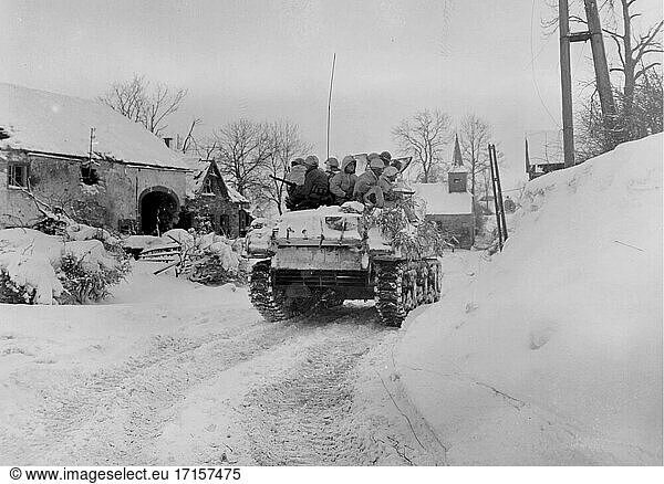 BELGIEN Schopen -- 21. Januar 1945 -- Mitglieder der Kompanie I,  3d Bataillon,  16. Infanterieregiment,  1. Division,  Erste US-Armee,  fahren auf einem Panzer während ihres Vormarschs auf die Stadt Schopen,  Belgien,  während eines großen deutschen Gegenangriffs,  der später als Ardennenoffensive bekannt wurde -- Bild von Bill Augustine / Lightroom Photos / US Army *Beste verfügbare Qualität. Nicht auf Staub oder Kratzer retuschiert.