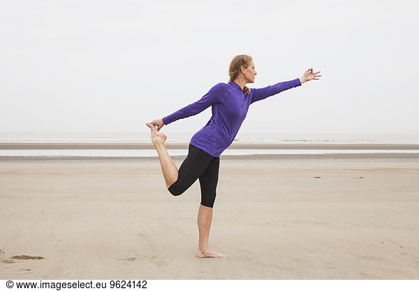 Belgium  Flanders  woman doing yoga exercises on the beach