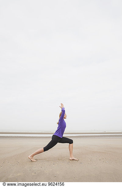 Belgium  Flanders  woman doing yoga exercises on the beach