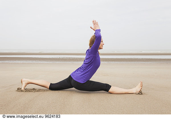 Belgium  Flanders  woman doing yoga exercises on the beach