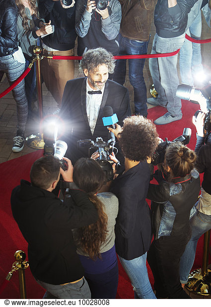 Berühmtheit wird von Paparazzi auf der Veranstaltung interviewt und fotografiert.