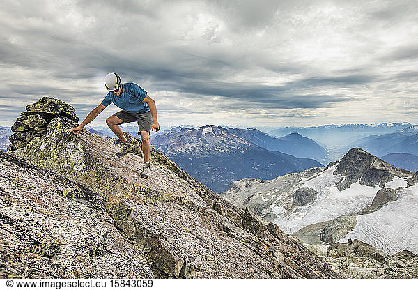 Bergsteiger wandert vorsichtig vom Gipfel eines Berges.