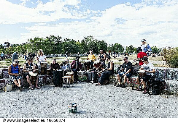 Berlin  Deutschland. Gruppe von Musikern  die an einem sonnigen Sommernachmittag im Mauerpark auf Trommeln musizieren.