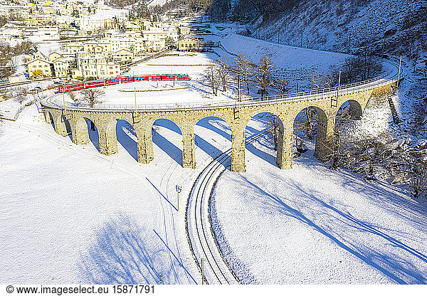 Bernina Express passes over the helical (spiral) viaduct of Brusio  UNESCO World Heritage Site  Valposchiavo  Canton of Graubunden  Switzerland  Europe