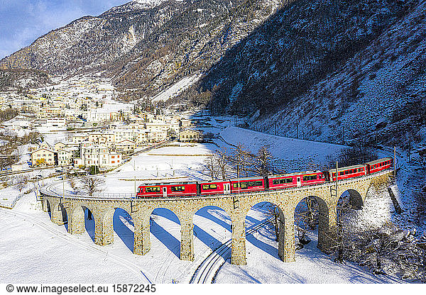 Bernina Express passes over the helical (spiral) viaduct of Brusio  UNESCO World Heritage Site  Valposchiavo  Canton of Graubunden  Switzerland  Europe