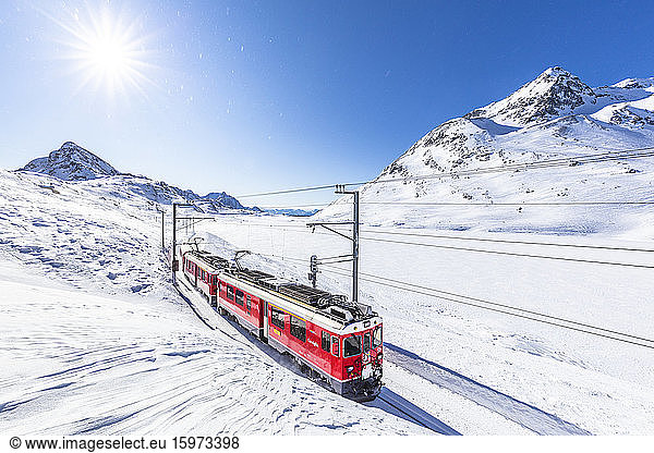 Bernina Express transit along Lago Bianco in winter  Bernina Pass  Engadine  Canton of Graubunden  Switzerland  Europe