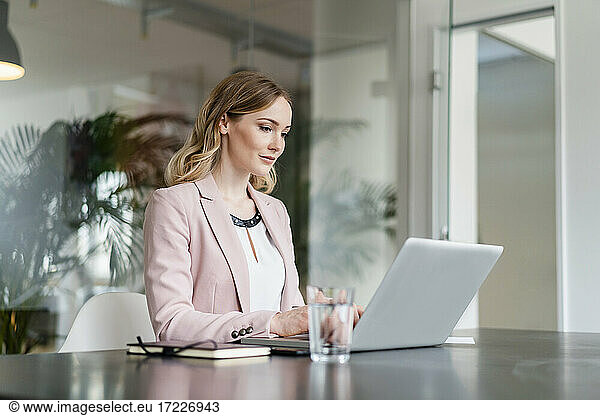 Berufstätige Frau arbeitet am Laptop am Schreibtisch