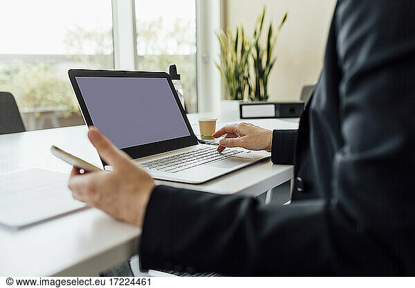 Berufstätige Frau mit Laptop am Schreibtisch
