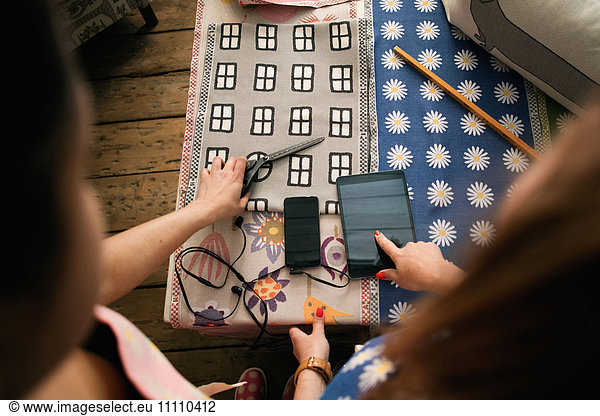 Besitzer zeigt und zeigt auf digitales Tablett während der Arbeit im Textilgeschäft