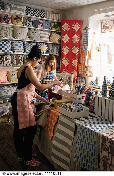 Besitzerinnen  die im Laden an Textilien arbeiten