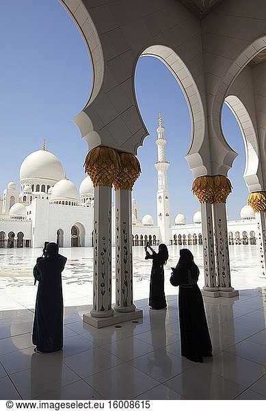 Besucher machen Fotos zwischen den vergoldeten Säulen der Sheikh Zayed Bin Sultan Al Nahyan Moschee  Abu Dhabi  Vereinigte Arabische Emirate  Naher Osten