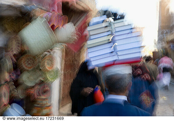 Bewegungsunscharfes Bild eines Mannes  der Bücher auf seinem Kopf trägt  Jemen