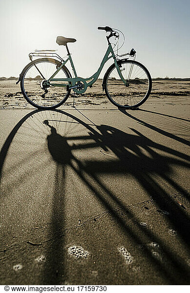 Bicycle with long shadow at Fangar Beach against clear sky  Ebro delta  Spain