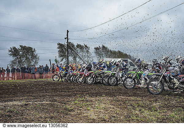Bikers with dirt bikes on field during competition
