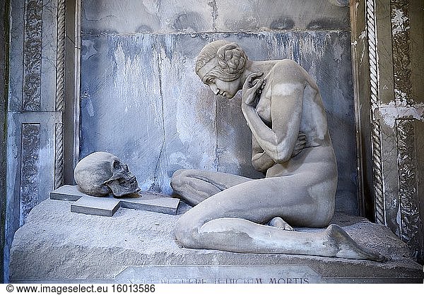 Bild und Abbildung der Steinskulptur eines Aktes  der einen Totenkopf auf einem Kruzifix betrachtet. Die im Jugendstil geschaffene Skulptur erinnert daran  dass Schönheit und Leben vergänglich sind. Das Lavarello-Grabmal  geschaffen von Demetrio Paernio 1914. Die Monumentalgräber auf dem Monumentalfriedhof von Staglieno  Genua  Italien.