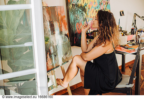 Bildende Künstlerin bei der Arbeit an einer Leinwand im Atelier für abstrakte Kunst