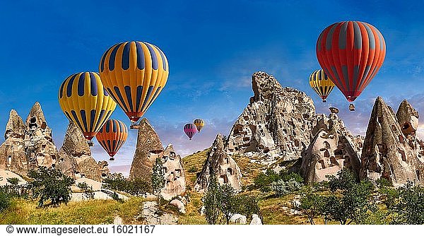 Bilder und Fotos von Heißluftballons über der Burg Uchisar und den Höhlenstadthäusern in den Felsformationen und dem Feenkamin von Uchisar  in der Nähe von Goreme  Kappadokien  Nevsehir  Türkei.