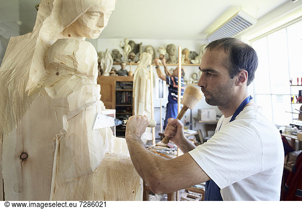 Bildhauer meißelnde Figur aus Holz